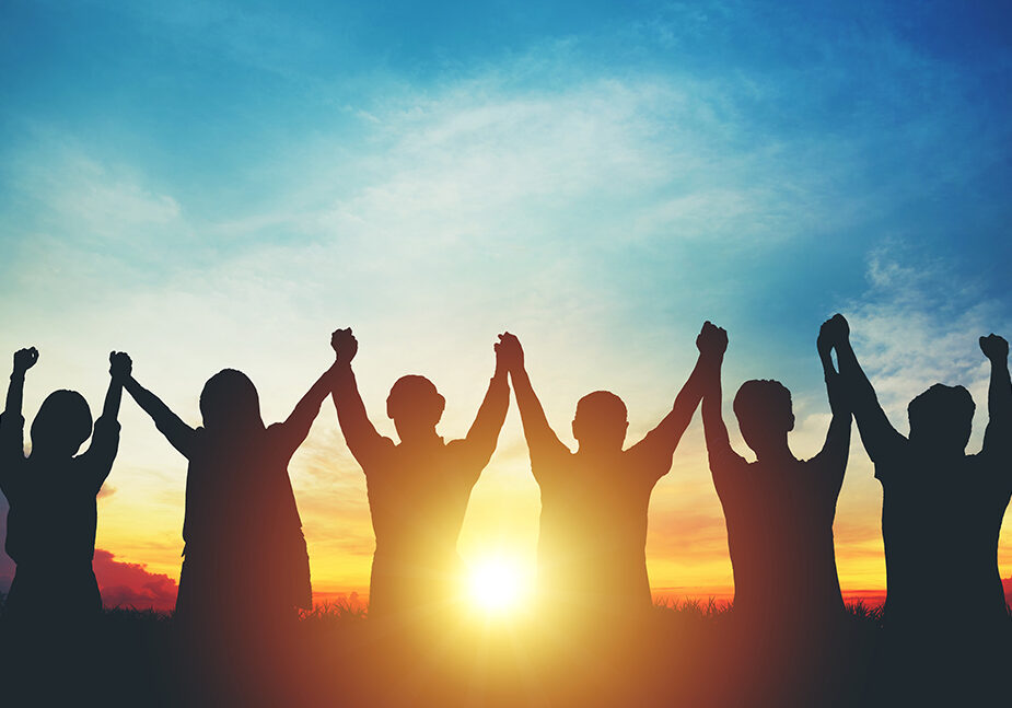 Silhouette of group business team making high hands over head in sunset sky evening time for business success and teamwork concept in company growth mergers and acquisitions start greeting etiquette